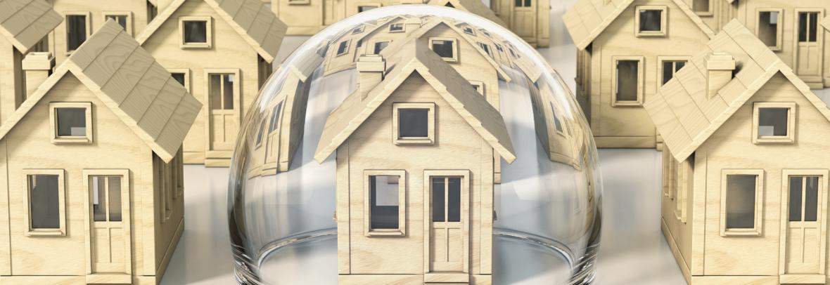 Small models of homes; the center one is covered in a bubble