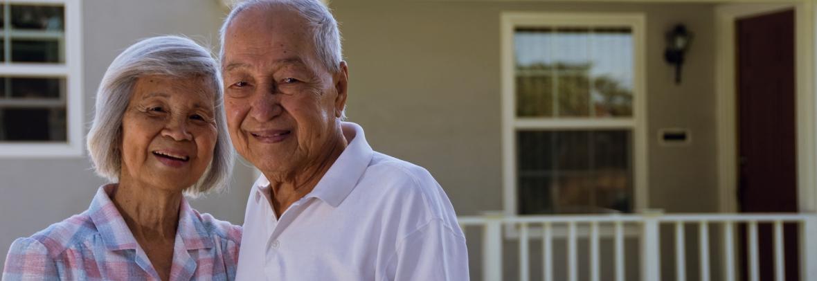 older couple standing outside house