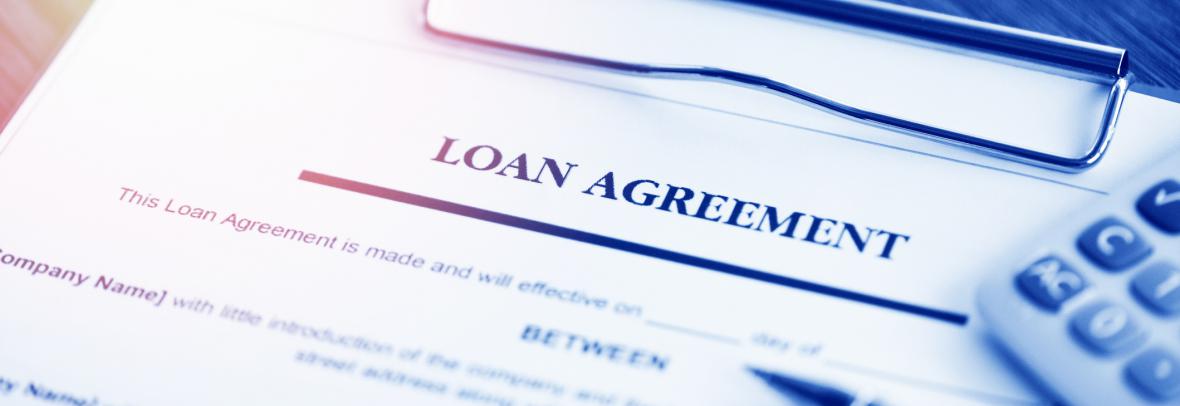 loan agreement paperwork with calculator and pen