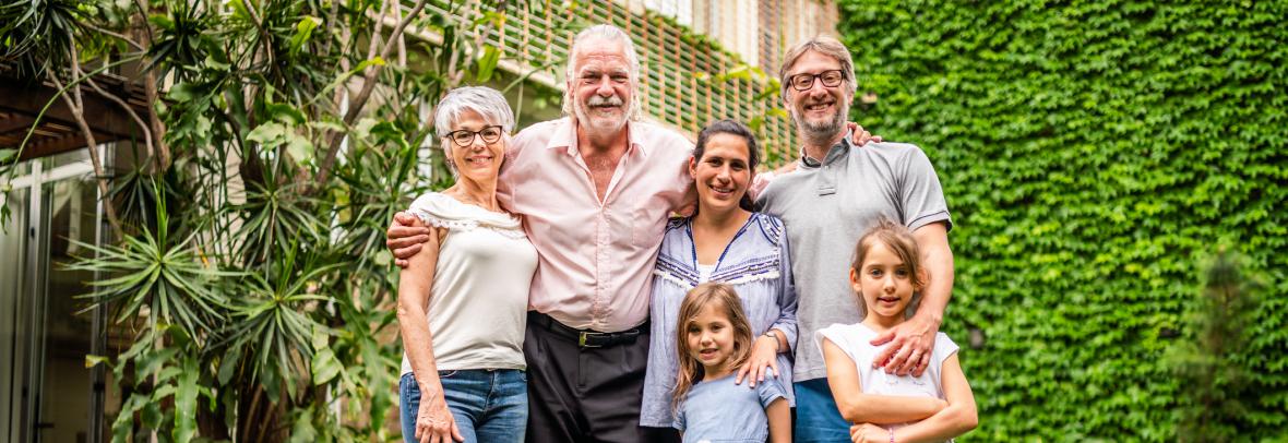 Five people from three generations tand in front of a house