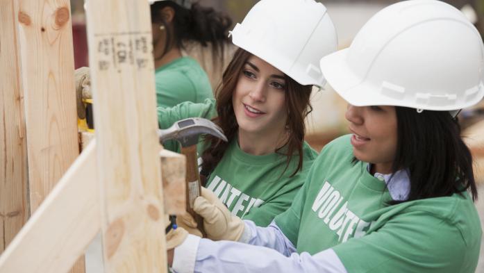 female volunteers working on a home construction site