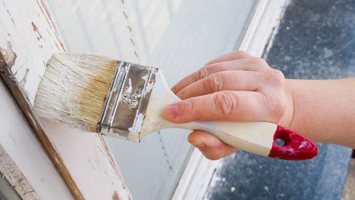 hand painting house with paintbrush