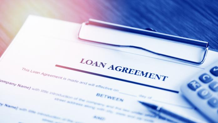 loan agreement paperwork with calculator and pen