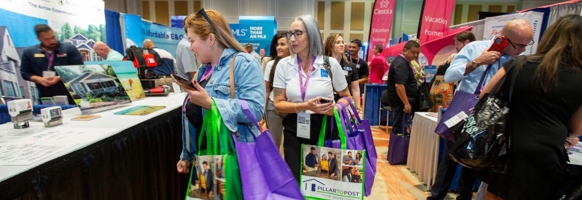 People carrying bags in crowded expo center