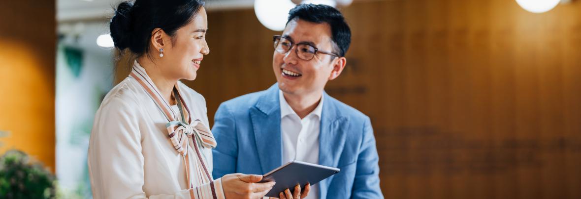 Asian business partners working on a digital tablet and laptop computer in the office. 