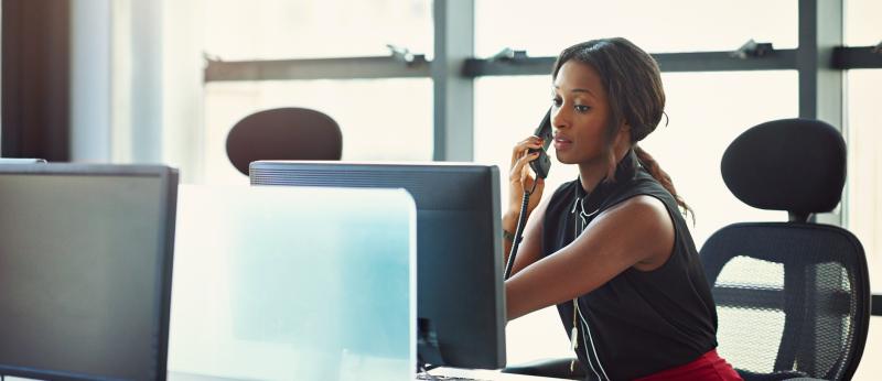woman at computer using telephone