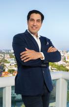 Photo of Andres Asion on a balcony overlooking the city