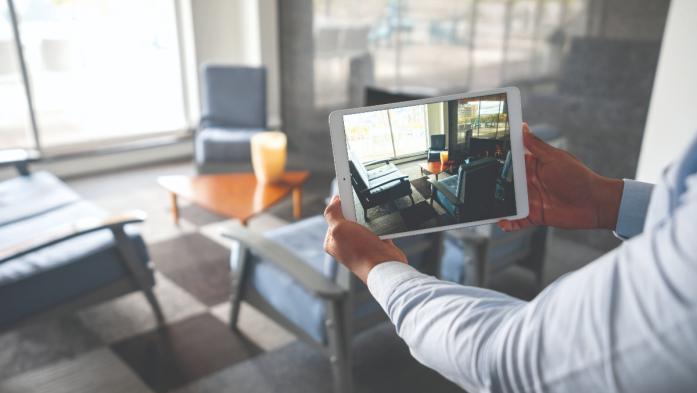 man holding ipad shooting video of a living room
