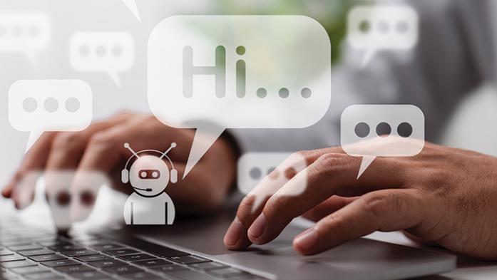 Photo of a persons hands on a computer keyboard and little white chatbot saying Hi