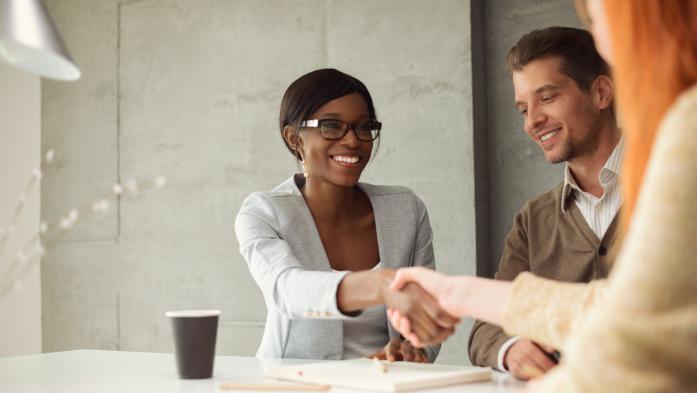 Couple shaking hands with financial adviser
