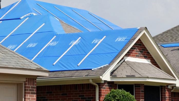 Blue tarps cover a roof